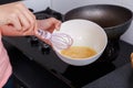 Close up of hand cooking and whisking eggs in a bowl in kitchen Royalty Free Stock Photo