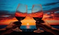 close-up hand of couple man and woman toasting a glass of wine on the background of the sea and sunset