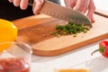 Close-up on a hand cutting green pepper with a santoku knife