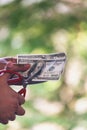 Close up hand cutting money usd banknote. Woman hand cuts money debt with scissors. Close up Hands holding scissors cutting 100