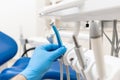 Close-up hand of dentist in the glove holds dental high speed turbine. Office where dentist conducts inspection and