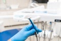 Close-up hand of dentist in the glove holds dental high speed turbine. Office where dentist conducts inspection and Royalty Free Stock Photo