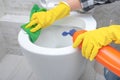 Close up hand with detergent cleaning toilet. Cleaning service. close up hands wearing yellow protect glove using liquid cleaning Royalty Free Stock Photo