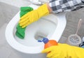 Close up hand with detergent cleaning toilet. Cleaning service. croped hands wearing yellow protect glove using liquid cleaning Royalty Free Stock Photo