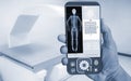 Hand Doctor showing Image of DXA bone density scan on a smartphone in analytics at Hologram human anatomy and skeleton to Royalty Free Stock Photo