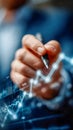 Close-up of a hand drawing an ascending financial graph with a pen on a digital screen Royalty Free Stock Photo