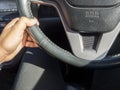 Close up hand driver control of car steering wheel
