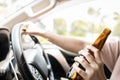 Close up,Hand of drunk woman holding bottle of beer,asian female driver drinking alcohol while driving motor vehicle,bad behavior, Royalty Free Stock Photo