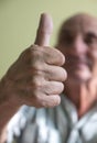 Close-up of hand of elderly like Caucasian man showing thumb up. A pensioner with an optimistic mood.