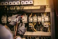 Close-up hand of electrical engineer using measuring equipment to checking electric current voltage at circuit breaker Royalty Free Stock Photo