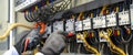 Close-up hand of electrical engineer using measuring equipment to checking electric current voltage at circuit breaker and cableCl Royalty Free Stock Photo