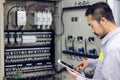 Close up hand of engineer or electrician man working check the electrical system with tablet at factory Royalty Free Stock Photo