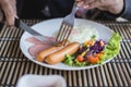 Close up hand on english breakfast - fried eggs, sausages, Ham a Royalty Free Stock Photo