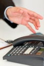 Close up of hand extending to office telephone