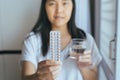 Close up of hand female holding birth control pill and a glass of water Royalty Free Stock Photo