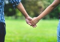 Close up hand of female and male holding together in park Royalty Free Stock Photo