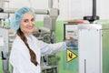 Woman manufacturing engineer adjusting the settings of an industrial machine