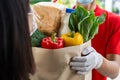 Close up hand food delivery service man wearing protection face mask holding fresh food set bag to customer