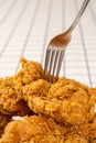 Close Up Hand and Fork on Fried Chickens on white Plate Isolated on table. Look Yummy and Yellow Gold Color