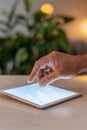 Close-up of a hand gently interacting with a glowing tablet screen in a soft-focused setting Royalty Free Stock Photo