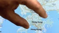 Close up hand gesture on touch screen zooming in Hong Kong city