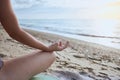 Woman sitting on the beach in lotus pose and meditating, body part, doing yoga exercise outdoors Royalty Free Stock Photo