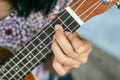 Close up hand girl play ukulele guitar at her home. Royalty Free Stock Photo