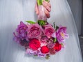 Close-up of the hand of girl in wedding dress who hold the bouquet of the bride. Royalty Free Stock Photo