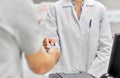 Close up of hand giving bank card to pharmacist