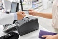 Close up of hand giving bank card to pharmacist