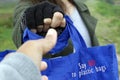 Close up of hand giving a blue women foldable shopping bag reusable eco with text message - Say no to plastic bags.