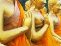 Close up hand of golden monk statues at public temple