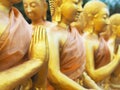 Close up hand of golden monk statues at public temple