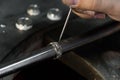 Close-up of hand of a goldsmith setting the diamond on the ring. Craft jewelery making with professional tools. Royalty Free Stock Photo