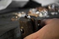 Close-up of hand of a goldsmith setting the diamond on the ring. Craft jewelery making with professional tools. Royalty Free Stock Photo