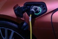 Close-up hand grip plug of industrial electric charging machine connected with socket charge on EV. car for rechargeable battery
