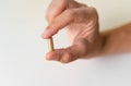 Close up hand with herb capsule on white background. Microdosing concept. Psychedelics therapy. Depression, anxiety