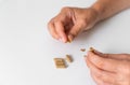 Close up hand with herb capsule on white background. Microdosing concept. Psychedelics therapy. Depression, anxiety