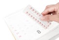 Close up hand hold birth-control pill with date of calendar back Royalty Free Stock Photo
