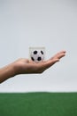 Hand holding acrylic football cube against white background