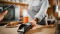 Close Up of a Hand Holding a Bank Terminal Used for NFC Payment Technology on Smartphone. Customer Royalty Free Stock Photo