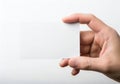 A close-up of a hand holding a blank white rectangular card or paper. isolated on white background Royalty Free Stock Photo