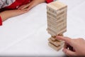 Close up hand holding blocks wood game -jenga, on white background Royalty Free Stock Photo