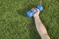 Close Up on Hand Holding Blue Dumbbell in Grass