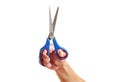 hand a human holding blue and red scissors on white background. Royalty Free Stock Photo