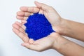 Close up of hand holding blue silica gel on Royalty Free Stock Photo