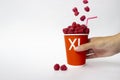 Close-Up Of Hand Holding Disposable Cup Fresh Raspberries Against White Background Royalty Free Stock Photo