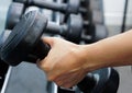 Close up of hand holding dumbbell in fitness or gym Royalty Free Stock Photo