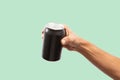 Close-up of hand holding Empty aluminum can with condensation. isolated on green