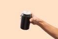 Close-up of hand holding Empty aluminum can with condensation isolated on salmon